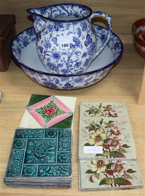 Thirteen Victorian and later pottery tiles, a jug and a basin